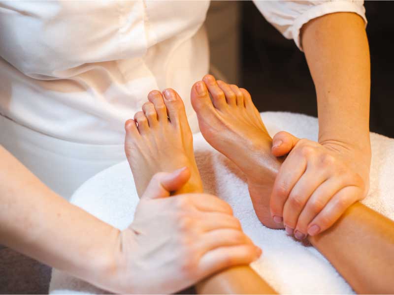 Masseuses hands relaxing stressed clients toes after busy work week medical treatment